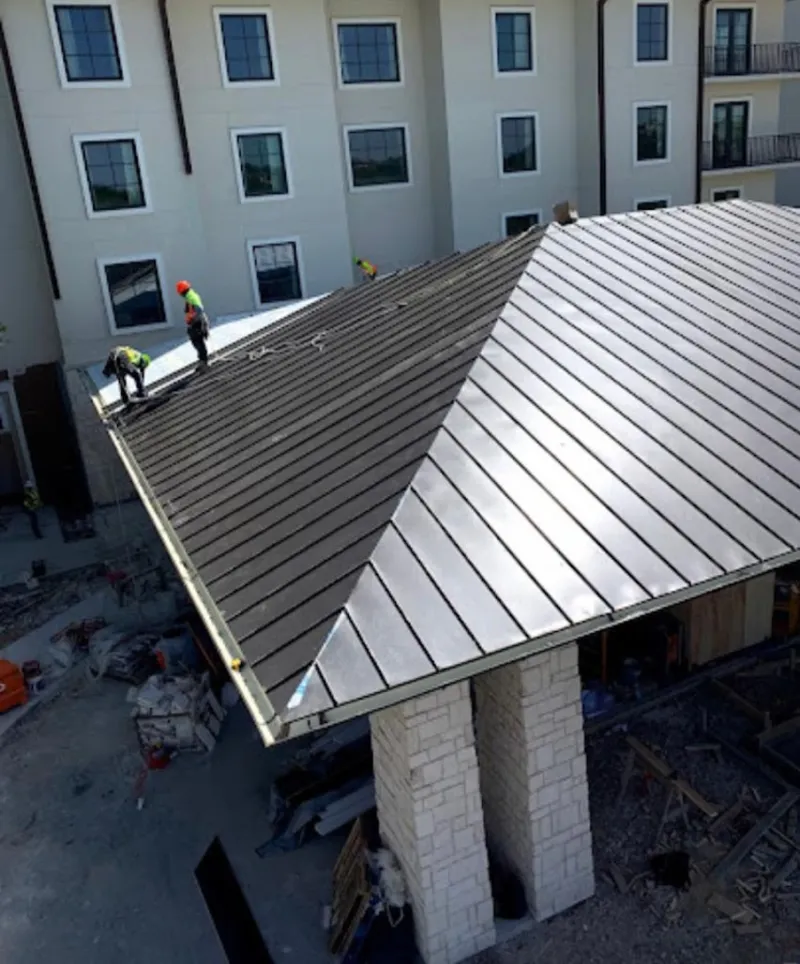 Crew installing standing seam metal roof panels on a commercial project in Morro Bay